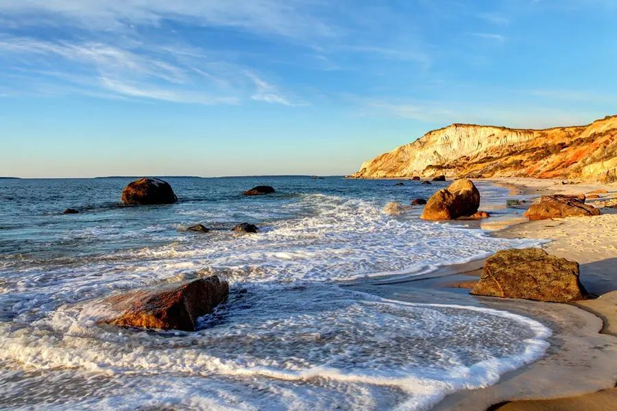 Woman walking barefoot along a Martha's Vineyard beach at the water's edge