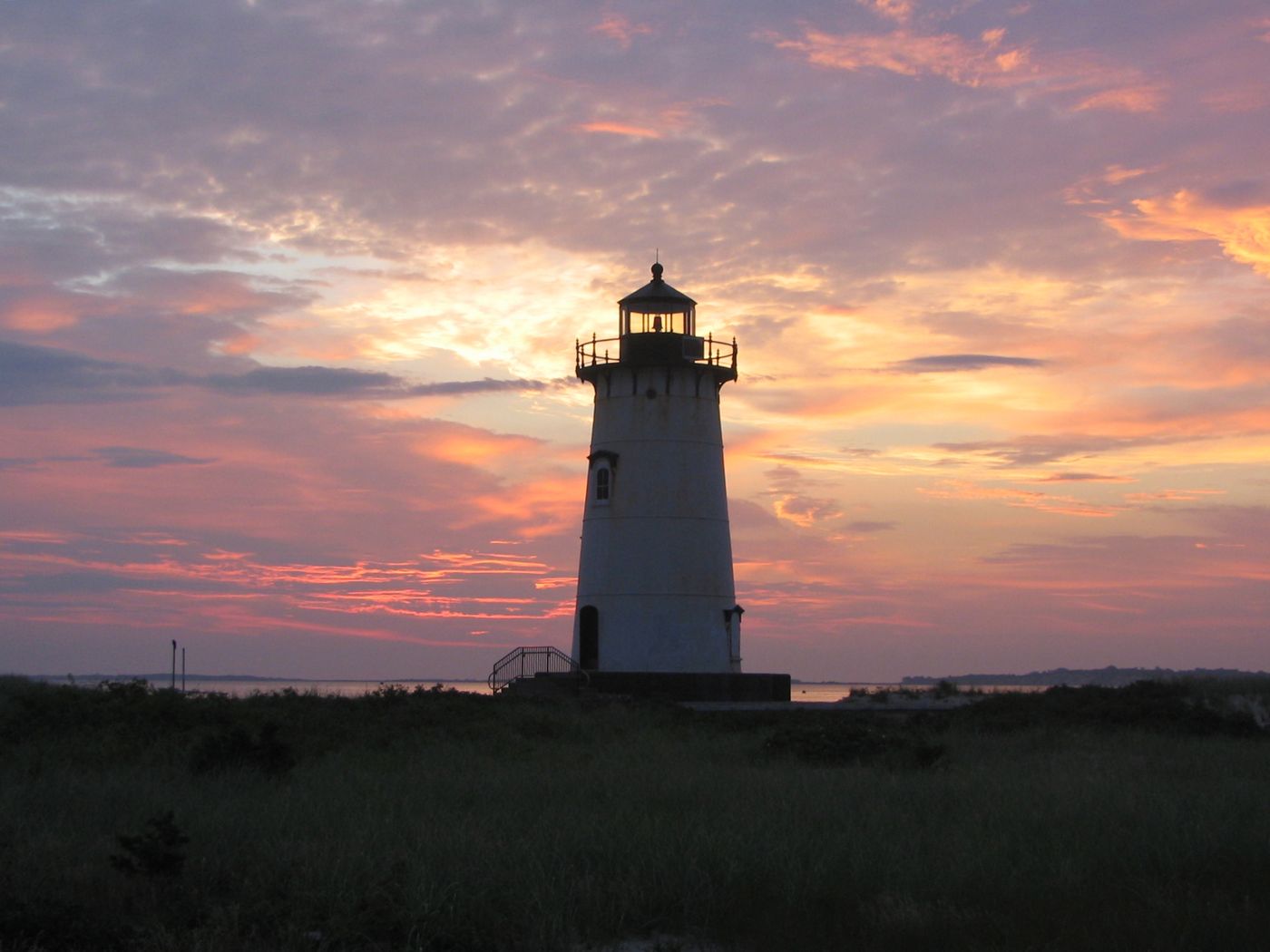 Edgartown Lighthouse silhouetted against a soft pink and lavender island sunset